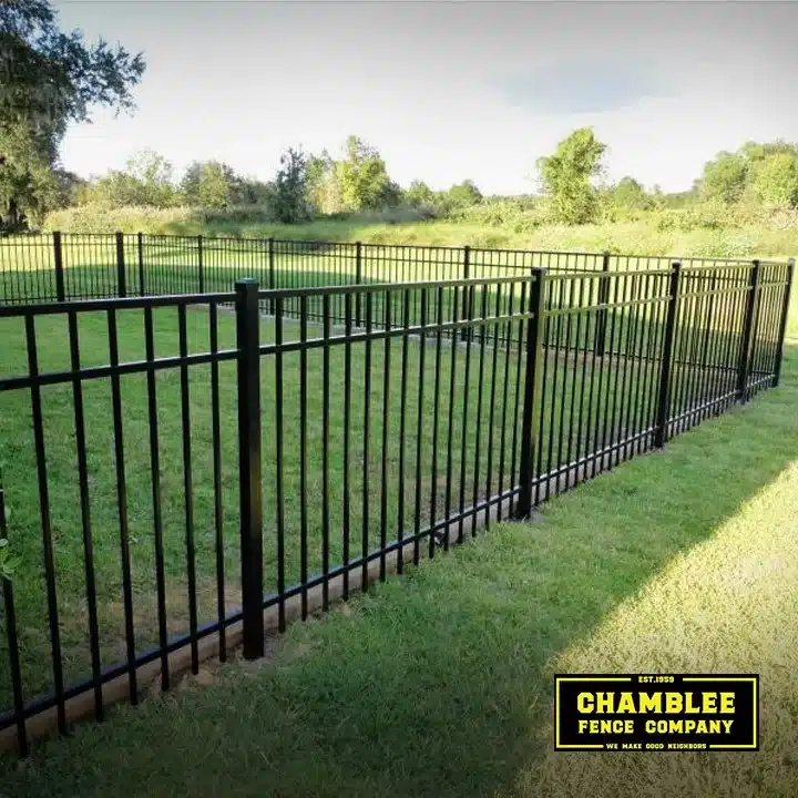 Black aluminum fence enclosing a green residential lawn installed by Chamblee Fence