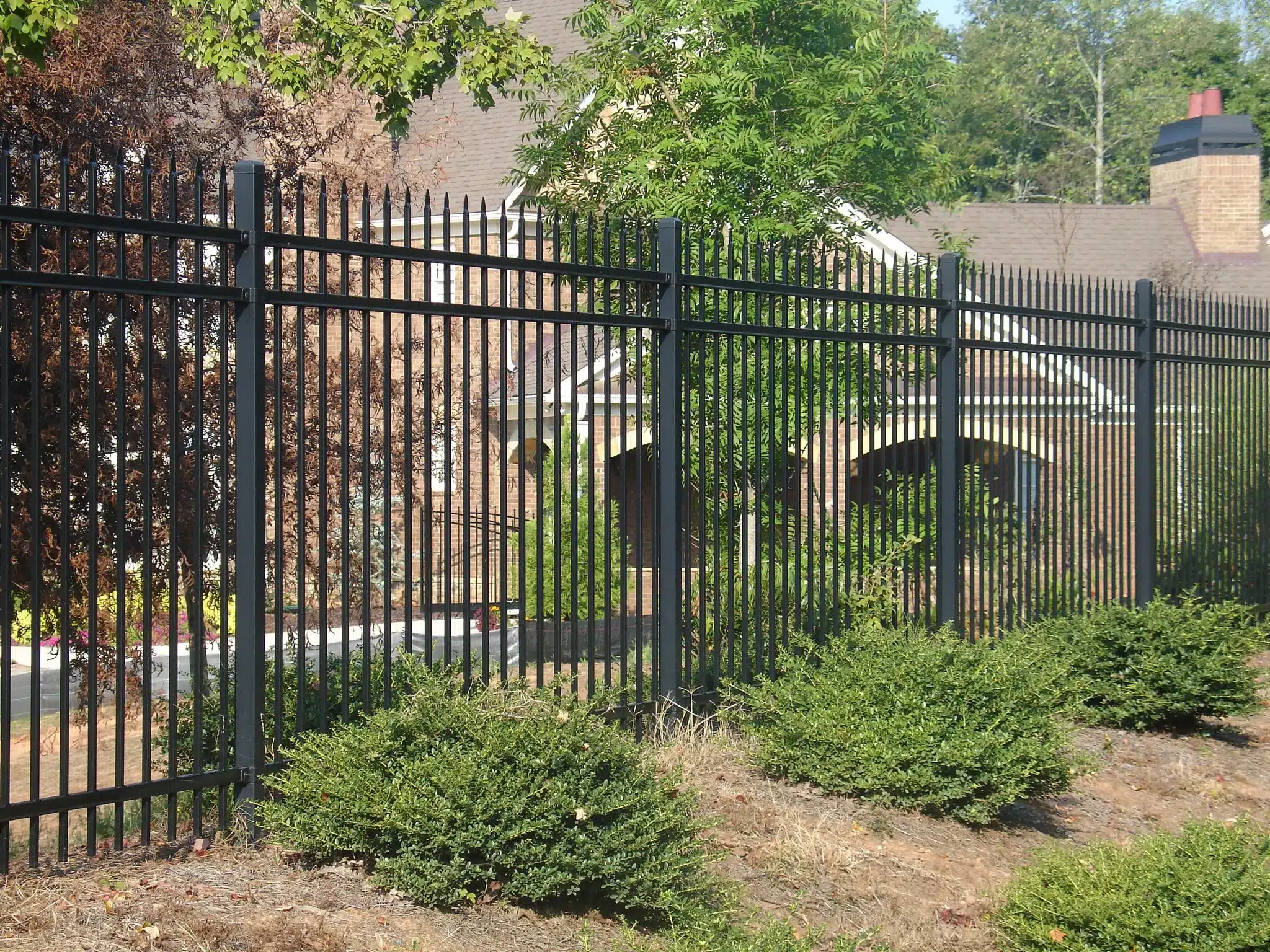 Residential home in Gwinnett County with a four-foot front yard fence and six-foot wooden backyard fence installed by Chamblee Fence Company, showcasing curb appeal, safety, and compliance with local regulations.