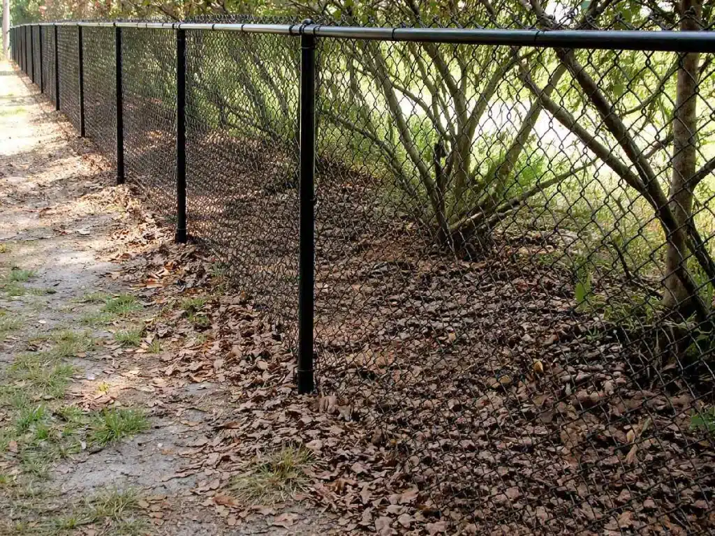 Black chain link fence installed along a wooded residential property line in Marietta, GA