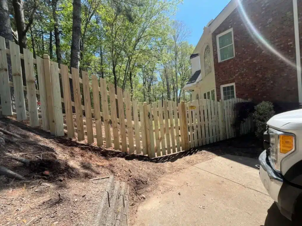 Wood picket fence and gate installed on a sloped residential property line in Marietta, GA