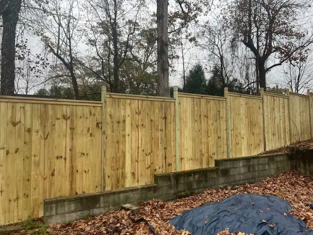 Wood privacy fence installed above a retaining wall on a residential property in Marietta, GA